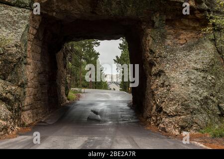 Ein Tunnel auf einer Straße mit Blick auf Mt. Rushmore in der Ferne. Stockfoto