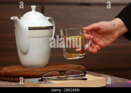 Verbringen angenehme Zeit mit Kräutertee und Bücher während dieser Tage bleiben wir zu Hause Stockfoto