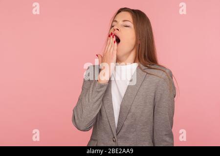 Porträt von schläfrig erschöpft junge Frau im Business-Anzug gähnend schön, Mund mit der Hand, Gefühl faul müde nach der Arbeit, braucht Ruhe. indo Stockfoto
