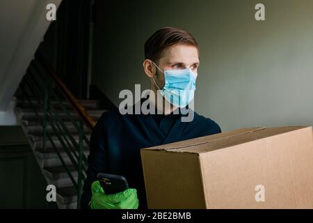 Lebensmittelgeschäft Lieferung Mann trägt medizinische Handschuhe und Gesichtsmaske. Online-Einkauf und Lieferung für Lebensmittel, Wein und Lebensmittel. Selbstquarantäne während Covid-19 Stockfoto