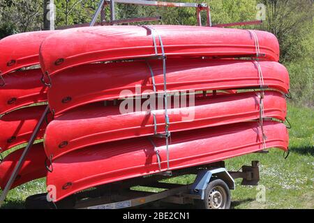 Rote Kanus auf einem Anhänger gestapelt Stockfoto