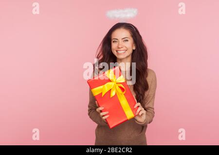 Porträt von glücklichen schönen Engel junge Frau mit Halo hält großes Geschenk und lächelnd Kamera, mit Geschenk zufrieden, Geburtstag feiern, annive Stockfoto