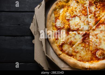 Kalte Pizza in einer Lieferbox, lange Lieferzeiten, verschwendete Fast-Food-Konzept. Italienische Pizza margherita mit trockener Kruste und Sauce, verzögertes oder fehlgeschlagenes Essen Stockfoto