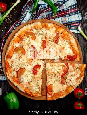 margherita Pizza mit Zitronenscheiben auf einem Holztablett Stockfoto