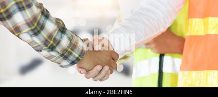 Nahaufnahme Ingenieur Hand schütteln mit Bauunternehmer in Baustelle, erfolgreiche Verhandlung von Manager und Industrievertrag Zusammenarbeit CO Stockfoto