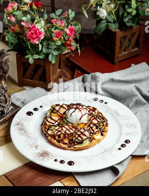 Waffel mit Früchten Banane Kiwifruit Vanille Eis und Schokolade Sauce Stockfoto