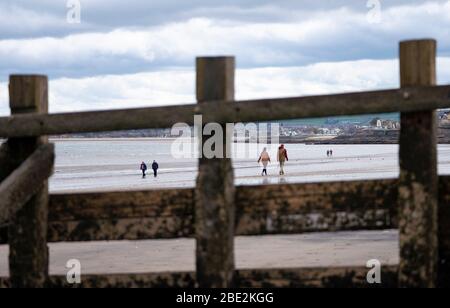 Portobello, Edinburgh. Schottland, Großbritannien. 11 April 2020. Am Osterwochenende am Samstagmorgen waren die Besucher draußen am Portobello Strand außerhalb von Edinburgh trainieren und spazieren gehen. Der beliebte Strand und die Promenade sind sehr ruhig und die Leute üben eine richtige soziale Distanz aus. Iain Masterton/Alamy Live News Stockfoto