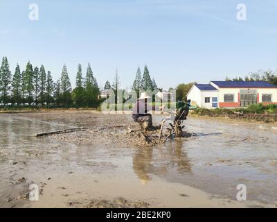 (200411) -- HUARONG, 11. April 2020 (Xinhua) -- EIN Bauer arbeitet mit einer Maschine auf dem Feld in Wanyu, Gemeinde Huarong, Provinz Hunan, Zentralchina, 9. April 2020. (Xinhua/Zhou Nan) Stockfoto