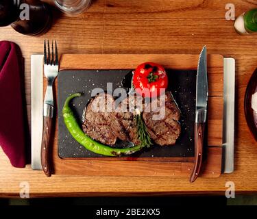 Von oben sehen Sie Rindersteaks mit gegrillter Tomate und Pfeffer Stockfoto