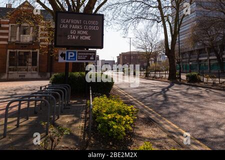Southend-on-Sea, Großbritannien. April 2020. Das elektronische Schild für öffentliche Gesundheit an der Victoria Avenue, Southend-on-Sea, zeigt eine Lockdown-Nachricht an, die die Bewohner dazu drängt, zu Hause zu bleiben und die Küste und Parkplätze zu meiden. Während der COVID-19-Pandemie erfasst, lautet das Schild: „SEAFRONT CLOSED / PARKING CLOSED / GO HOME / STAY HOME“. Die leere Straßenszene spiegelt die Auswirkungen von Notbeschränkungen auf das städtische Leben wider. Penelope Barritt/Alamy Live News Stockfoto