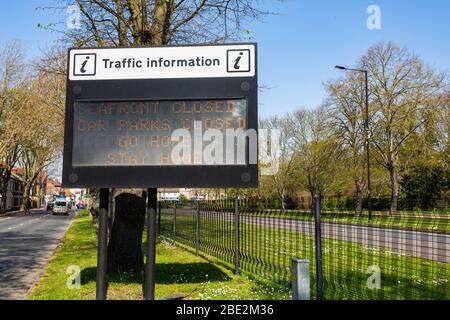 Southend-on-Sea, Großbritannien. April 2020. Das elektronische Verkehrsinformationsschild an der Victoria Avenue, Southend-on-Sea, zeigt eine Meldung der öffentlichen Gesundheit, in der die Bewohner während der COVID-19-Pandemie aufgefordert werden, zu Hause zu bleiben. Der beleuchtete Text lautet: „AM MEER GESCHLOSSEN / PARKPLÄTZE GESCHLOSSEN / NACH HAUSE GEHEN / ZU HAUSE BLEIBEN.“ Das Schild befindet sich neben einer mehrspurigen Straße mit Metallzäunen und Bäumen im Hintergrund unter klarem blauen Himmel. Penelope Barritt/Alamy Live News Stockfoto