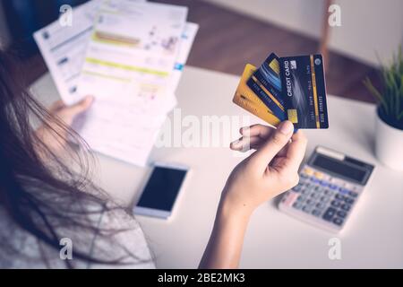 Nahaufnahme Hand der Frau, die drei Kreditkarten hält, Gefühl über Steuer- und Schuldenproblem vom Einkaufen online gestresst. Stockfoto