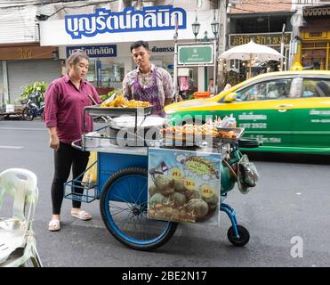 Bangkok, Thailand - 27. Februar 2020: Ein traditioneller Lebensmittelhändler und Kunde, auf einer Bangkok Straße. Stockfoto