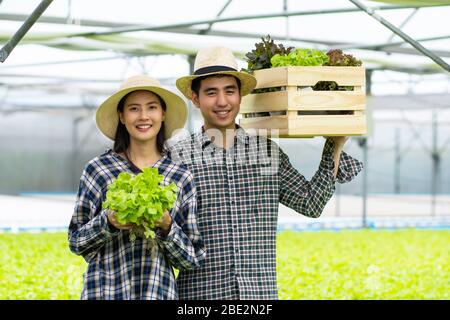 Bauer Mann und Frau halten hydroponic in Bauernhof Stockfoto