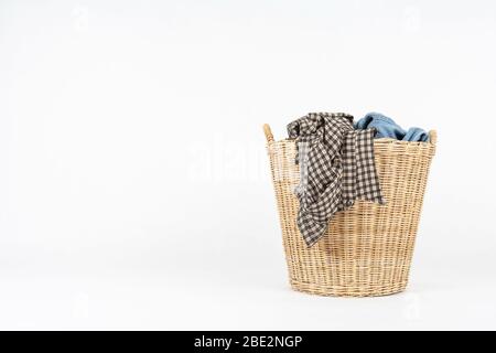 Korbkorb mit Kleidung isoliert auf weißem Hintergrund Stockfoto