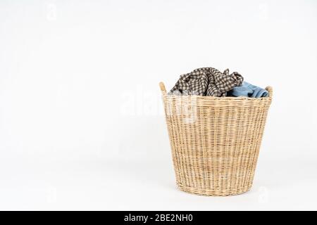 Korbkorb mit Kleidung isoliert auf weißem Hintergrund Stockfoto