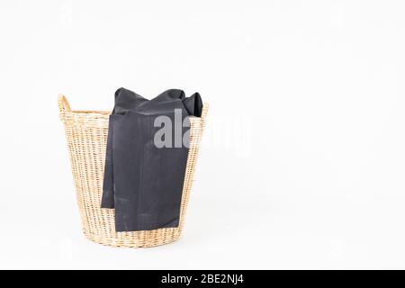 Korbkorb mit Kleidung isoliert auf weißem Hintergrund Stockfoto