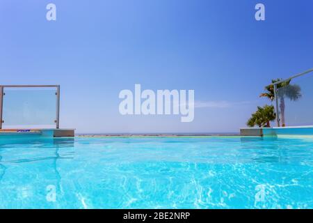 Luxus-Swimmingpool und blaues Wasser im Resort mit herrlichem Meerblick. Stockfoto