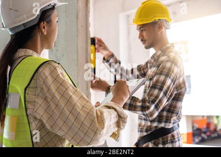 Team von Inspektor hält Zwischenablage öffnen Papier und Überprüfung Gebäude für Renovierung, Ingenieur Vermessungsor in der Baustelle suchen. Home inspectio Stockfoto