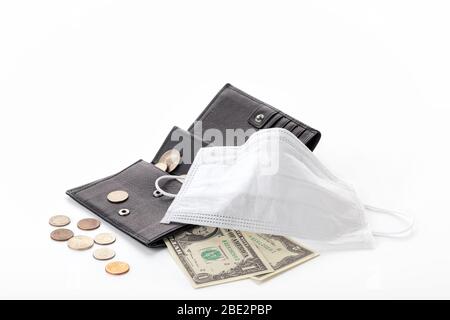 Konzept einer globalen Krise und sinkende Einkommen durch pandemische Coronavirus COVID-19. Geldbörse mit einem Dollar, Cent und einer Schutzmaske isoliert auf Stockfoto
