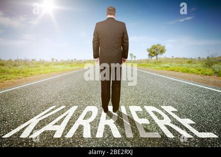 Ein Geschaeftsmann auf einer einsamen Straße, auf der 'Karriere' steht Stockfoto