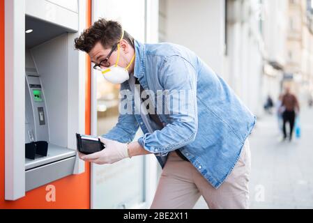 Mann entsetzt über einen Geldautomaten, finanzielle Not während der Zeit der Korona-Krise Stockfoto