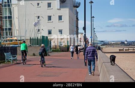 Portobello Promenade, Edinburgh, Schottland, Großbritannien. April 2020. Temperatur von 16 Grad mit voller Sonne am Nachmittag nach einem bewölkten Start. Am Ostersamstag ein sehr ruhiger Strand am dritten Wochenende der Coronavirus Lockdown. Auf der Promenade manchmal fast so viele Radfahrer wie Fußgänger in Gruppen von bis zu fünf Personen aller Altersgruppen ankommen, leider nicht alle geben eine körperliche soziale Distanz, wie sie passieren, so dass es unangenehm war, die entlang gehen. Quelle: Arch White / Alamy Live News. Stockfoto