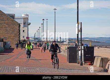 Portobello Promenade, Edinburgh, Schottland, Großbritannien. April 2020. Temperatur von 16 Grad mit voller Sonne am Nachmittag nach einem bewölkten Start. Am Ostersamstag ein sehr ruhiger Strand am dritten Wochenende der Coronavirus Lockdown. Auf der Promenade manchmal fast so viele Radfahrer wie Fußgänger in Gruppen von bis zu fünf Personen aller Altersgruppen ankommen, leider nicht alle geben eine körperliche soziale Distanz, wie sie passieren, so dass es unangenehm war, die entlang gehen. Quelle: Arch White / Alamy Live News. Stockfoto