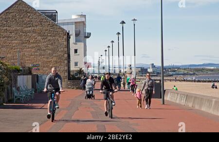 Portobello Promenade, Edinburgh, Schottland, Großbritannien. April 2020. Temperatur von 16 Grad mit voller Sonne am Nachmittag nach einem bewölkten Start. Am Ostersamstag ein sehr ruhiger Strand am dritten Wochenende der Coronavirus Lockdown. Auf der Promenade manchmal fast so viele Radfahrer wie Fußgänger in Gruppen von bis zu fünf Personen aller Altersgruppen ankommen, leider nicht alle geben eine körperliche soziale Distanz, wie sie passieren, so dass es unangenehm war, die entlang gehen. Quelle: Arch White / Alamy Live News. Stockfoto