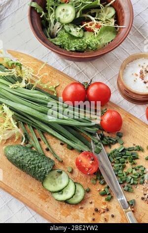 Hintergrund der Diätkost: Gemüsesalat mit Kirschtomaten und Gurken, Kohl, Salat, vegane Küche. Helle Farben des Frühlings, des Sommers. Gesund e Stockfoto