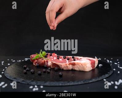 Rohes Fleisch auf einem Teller mit Salz und Wacholderbeeren Stockfoto