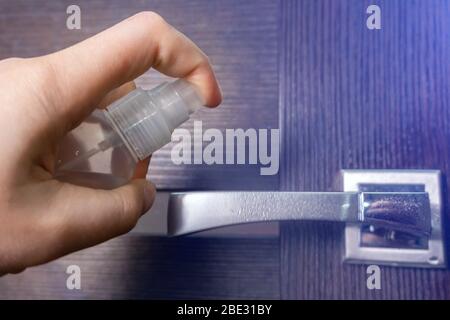 Türgriff mit Desinfektionsmittel. Desinfizieren und entfernen Sie Viren von der Griffoberfläche. Verhindern Sie die Ausbreitung des Coronavirus. Stockfoto