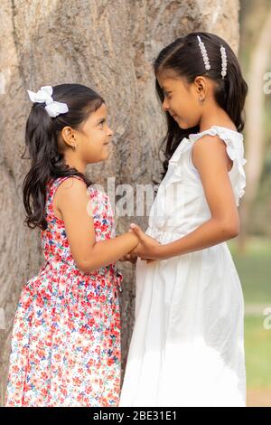 Zarte kleine Schwestern umarmen einander und zeigen ihre wahre Liebe Stockfoto