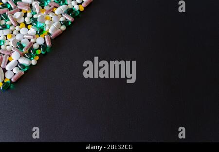 Viele verschiedene Medikamente, Pillen, Tabletten, Kapseln machen Dreieck in der Ecke des schwarzen matten Hintergrund. Medizinische Apotheke Hintergrund. C Stockfoto