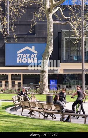 Die Menschen ignorieren Regierungsempfehlungen auf LED-Bildschirm und bevölkern Leicester Square während der Sperrung in London wegen Coronavirus Pandemie covid 19 Ausbruch Stockfoto