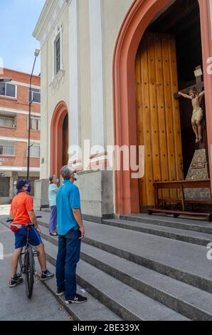 10. April 2020, Caracas, Miranda, Venezuela: Männer und eine Frau beten vor der Tür einer geschlossenen Kirche in Caracas während einer untypischen Karwoche, die durch die Quarantäne des Covid-19 verursacht wurde. (Bild: © Jimmy Villalta/ZUMA Wire) Stockfoto