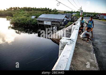 Kinder spielen in einem kleinen Dorf von Siargao Stockfoto