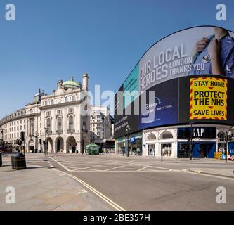 Regierungsnachrichten auf LED-Bildschirm an einem leeren, verlassenen Piccadilly Circus während der erzwungenen Sperrung in London wegen Coronavirus Covid 19 Grippe-Pandemie Stockfoto