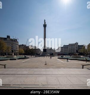 Ein sonniger Frühlingstag im leeren, menschenleeren und ruhigen Trafalgar Square, London während Covid 19, erzwang die Coronavirus-Grippe-Pandemie die Sperrung. Stockfoto