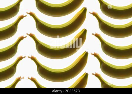 Ein wunderbares Bild von einem interessanten Muster von Bananen, vor einem hellen weißen Hintergrund, flat Stockfoto