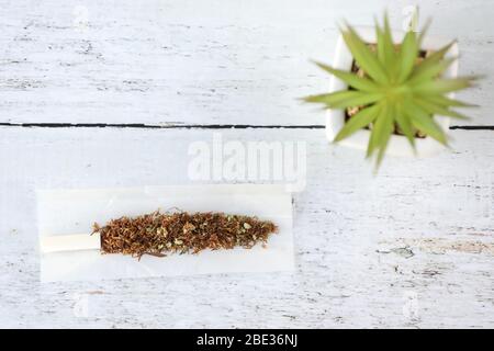 Cannabis Joint mit Tabak auf einem Holztisch. Legalisierung von Cannabis. Medizinische Verwendung. Stockfoto