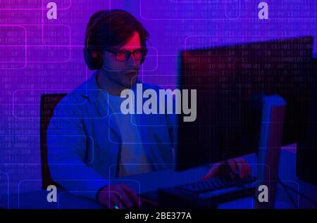 Programmierung in Kopfhörer am Computer. Doppelbildschirm mit Binärcode Stockfoto