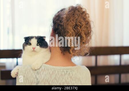 Mädchen, das eine Katze auf der Schulter hält Stockfoto