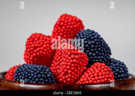 Gummy Bonbons mit Fruchtgeschmack in Holzschale auf weißem Hintergrund Stockfoto