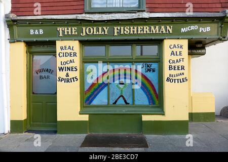 Das Jolly Fisherman Pub in Hastings, das während der Sperrung des Coronavirus geschlossen wurde, zeigt einen in Solidarität gemalten Regenbogen mit einer Botschaft, um sicher zu bleiben Stockfoto