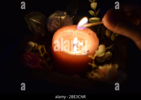 Nahaufnahme der rosa Kerze mit dunklem Hintergrund auf der Rückseite mit Platz, um Text hinzuzufügen Stockfoto