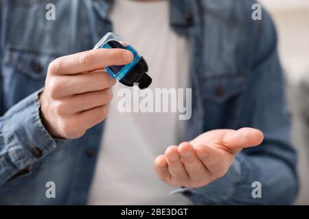 Junger Mann gießt Desinfektionsgel auf die Hände zur Desinfektion Stockfoto