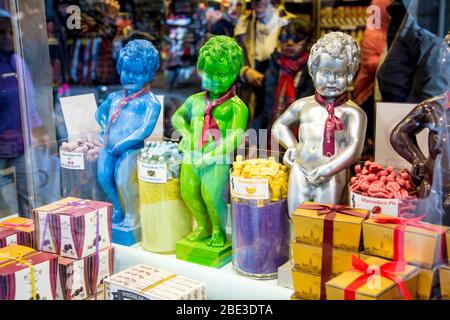 Bunte Nachbildungen der Skulptur Manneken Pis in einem Schaufenster für Süßwarenladen, Brüssel, Belgien Stockfoto