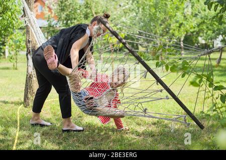 Teen Schwester Mädchen und Kind mit Spaß auf Hängematte im Garten, glücklich lachende Mädchen Stockfoto