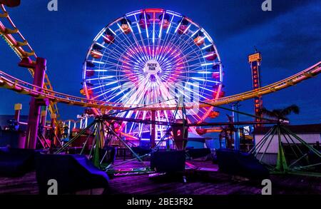 Santa Monica, Kalifornien, USA. April 2020. Das Pacific Wheel am Santa Monica Pier durchläuft seine Lichtshow als Hommage an die Ärzte, Krankenschwestern und andere medizinische Mitarbeiter an der Front, die gegen die COVID-19-Pandemie kämpfen. Kredit: Brian Cahn/ZUMA Wire/Alamy Live News Stockfoto